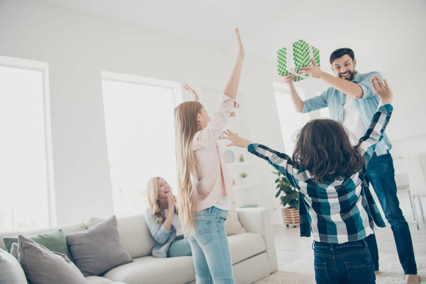 Photo of young foster family two children raising hands air receive unexpected giftbox glad to have best parents - Foto, imagen