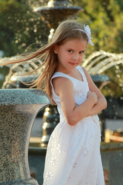Caucasian lovely smiling child girl near fountain in sammer - Photo, image