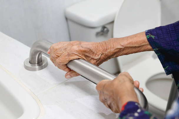 Idős asszony gazdaságot, korlát, fürdőszoba - Fotó, kép
