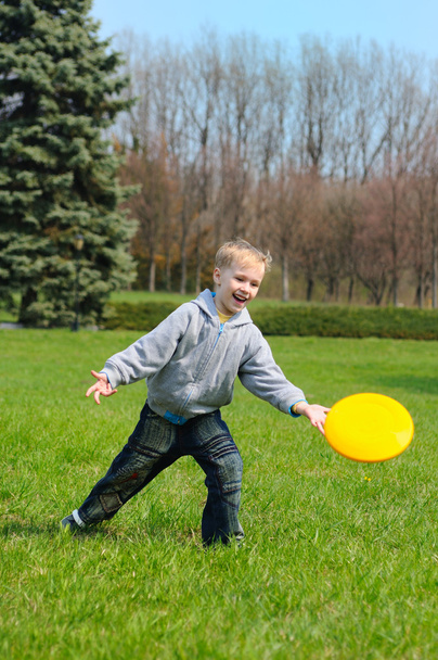 Menino está jogando Frisbee
 - Foto, Imagem