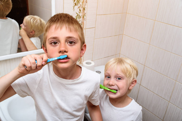 二人の少年が浴室で徹底的に歯を磨く。朝の衛生 - 写真・画像
