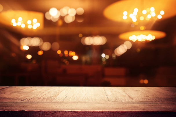 background Image of wooden table in front of abstract blurred restaurant lights - Foto, immagini