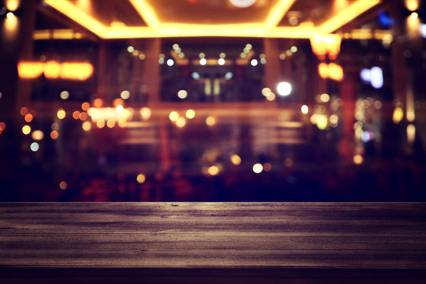 фон Зображення дерев'яного столу перед абстрактними розмитими вогнями ресторану
 - Фото, зображення