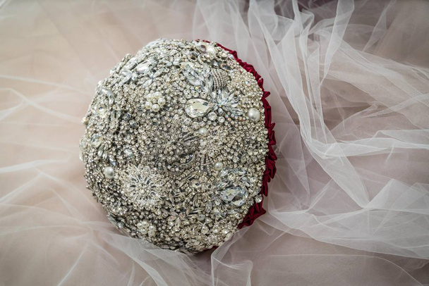 Brautstrauß aus Schmucksteinen auf dem Hintergrund des Hochzeitstülls. - Foto, Bild