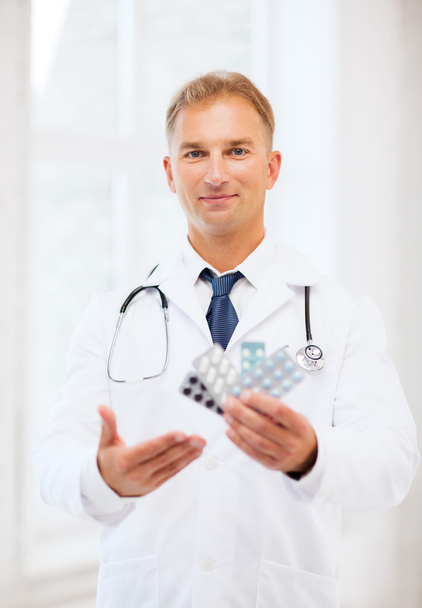 Young male doctor with packs of pills - Fotoğraf, Görsel