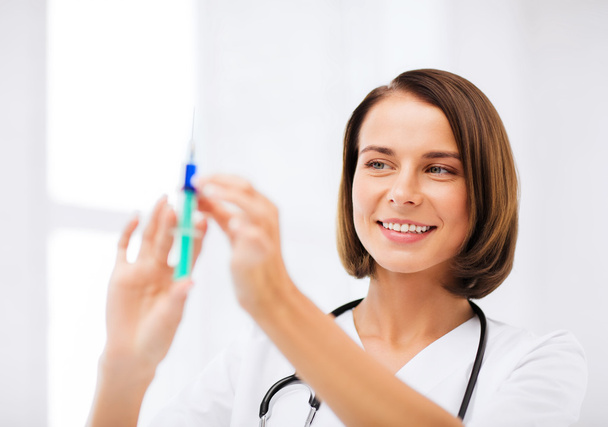 Female doctor holding syringe with injection - Foto, afbeelding