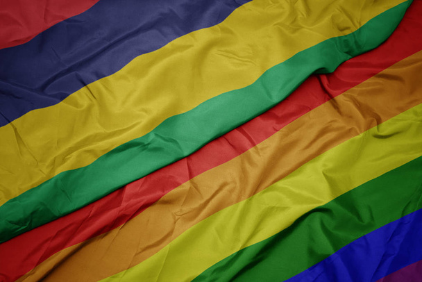 waving colorful gay rainbow flag and national flag of mauritius. - Photo, Image