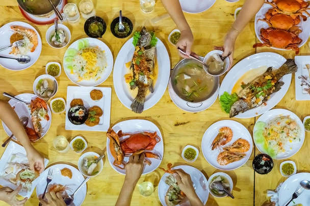 Top view of Happiness family enjoy eating with a variety of seafood dishes on dinner. - Photo, image