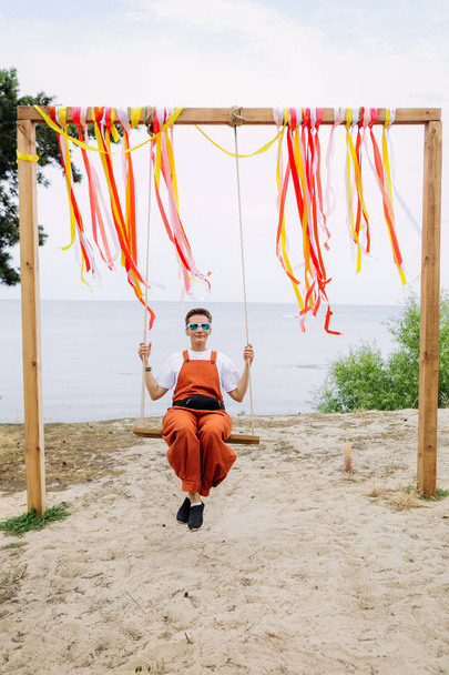 girl alone beach orange jumpsuit clothes sunglasses - Фото, изображение