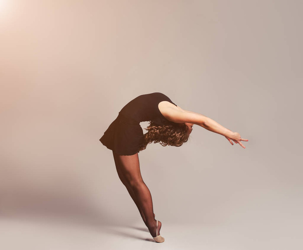 Young beautiful dancer gymnastics posing in studio - Фото, зображення