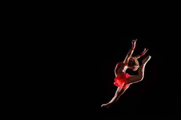 Fiatal, gyönyörű táncos tornász jumping a stúdióban - Fotó, kép