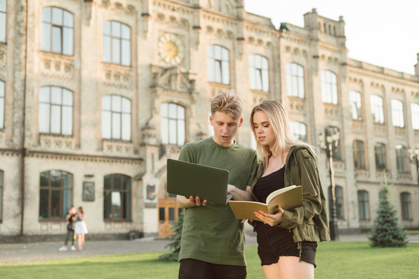 Dois jovens estudantes atraentes olhando para a tela do laptop, fazendo
 - Foto, Imagem