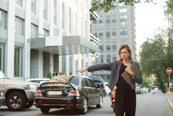 Занятая успешная деловая женщина в формальной одежде ловит такси на
  - Фото, изображение