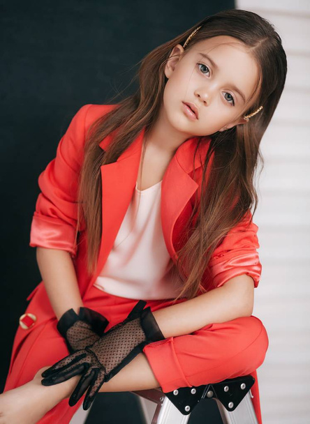 портрет красивой маленькой девочки в красном костюме
 - Фото, изображение