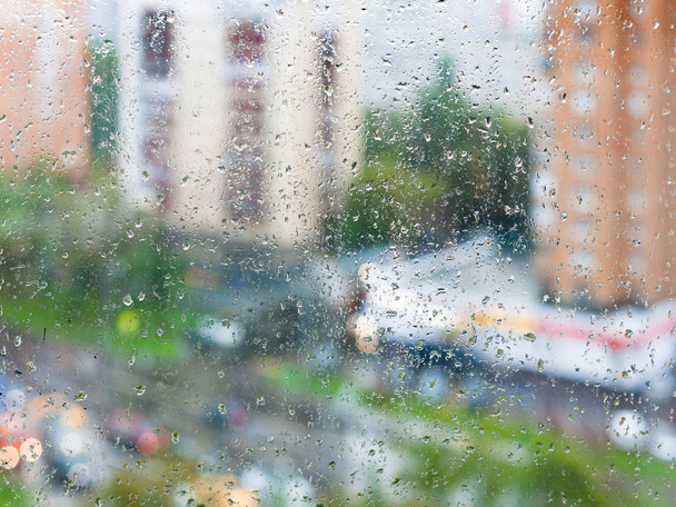 esőcseppek a haza ablak üveg és homályos utcában - Fotó, kép