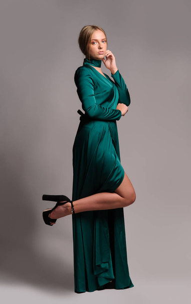 Pretty girl in green dress. Studio picture, grey background - Zdjęcie, obraz