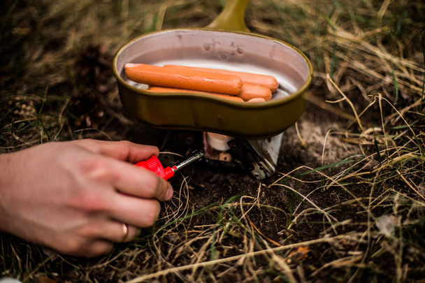 Cocinar salchichas mientras viajas en una sartén
 - Foto, Imagen