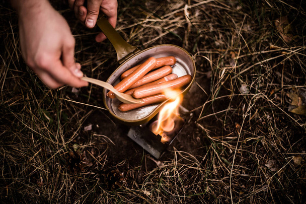 Worstjes worden gebakken over een open vuur in een pan - Foto, afbeelding