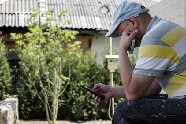 Lavoratore a riposo con un telefono cellulare in mano. Malattia del XXI secolo
 - Foto, immagini