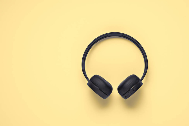 Επίπεδη σχεδίαση, ασύρματα ακουστικά σε κίτρινο φόντο με χώρο αντιγραφής - Φωτογραφία, εικόνα