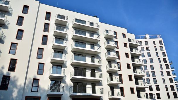 日中の現代的な住宅の建物の外観。青い空の晴れた日に現代的なアパートの建物。近代的なアパートのファサード - 写真・画像
