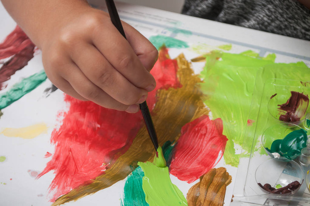 Primer plano de la mano de la pintura infantil sobre papel con pincel
 - Foto, Imagen