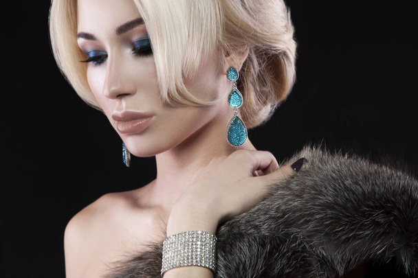 Portret van de jonge blonde vrouw met trendy accessoires en stijlvolle make-up poseren op zwarte achtergrond - Foto, afbeelding
