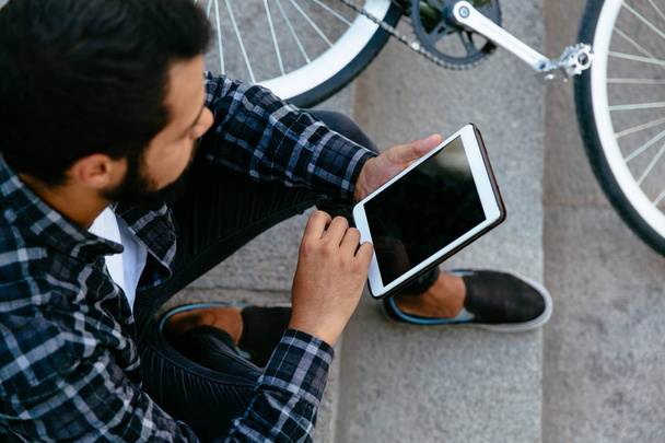 Close-up view of hipster man with tablet, sitting outdoors. - Foto, afbeelding
