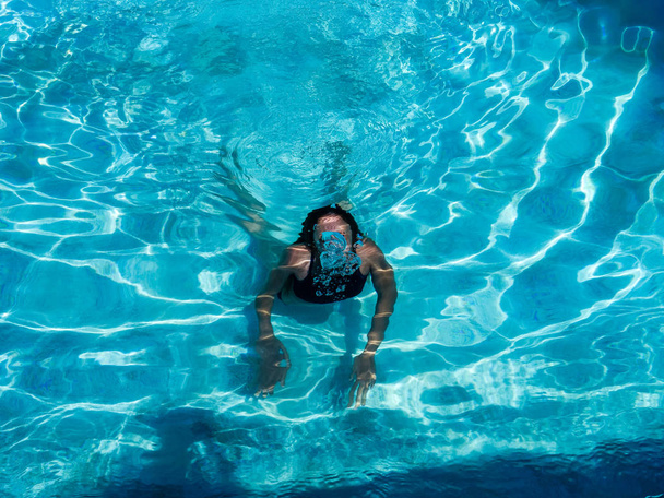 ziemlich athletisch sonnengebräuntes Mädchen plantscht im Urlaub in einem Swimmingpool - Foto, Bild