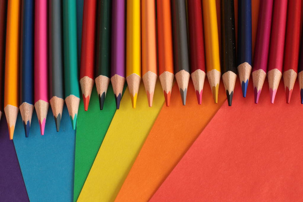 σειρά μακροεντολών, χρωματιστά μολύβια για δημιουργικότητα στο φόντο των φύλλων χαρτιού - Φωτογραφία, εικόνα