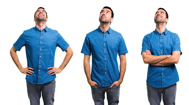 Conjunto de homem bonito com pé camisa azul e olhando para cima
 - Foto, Imagem