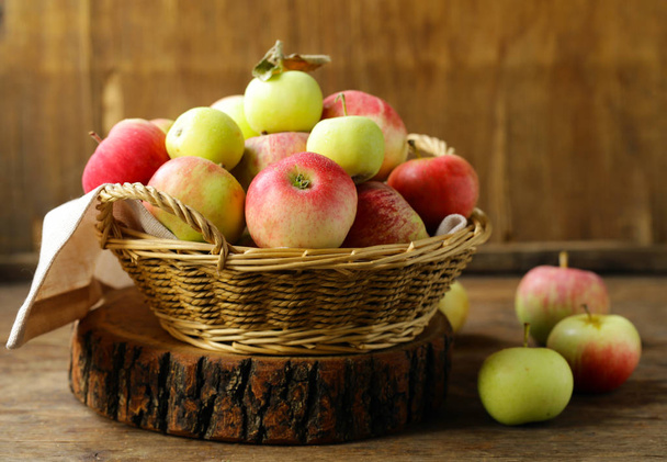 органические яблоки в плетеной корзине на столе
 - Фото, изображение