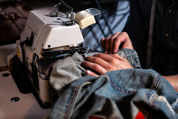 Eurooppalainen mies ompelee vaatteita ompelupajassaan kotona
. - Valokuva, kuva