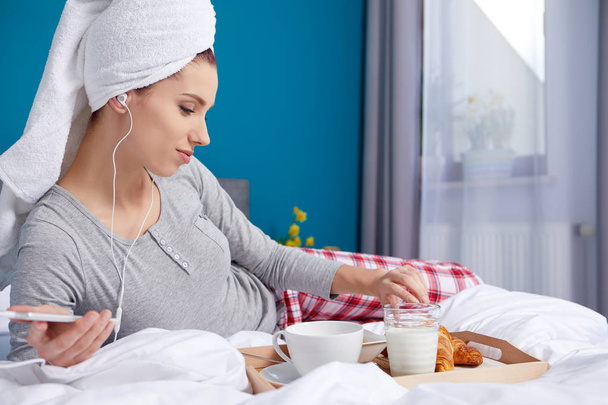 Girl with a towel on her head eating breakfast in bed - Foto, Bild