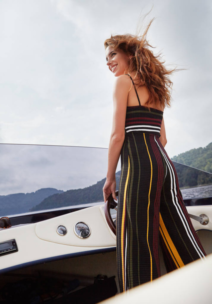 Summer vacation - young woman driving a motor boat  - Fotó, kép