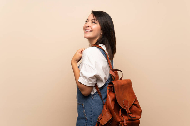 Sırt çantası ile izole arka plan üzerinde Genç Meksikalı kadın - Fotoğraf, Görsel