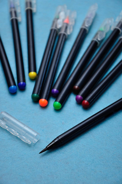Černé barevné pero s ostatním zaostřovačem na modrém pozadí - Fotografie, Obrázek