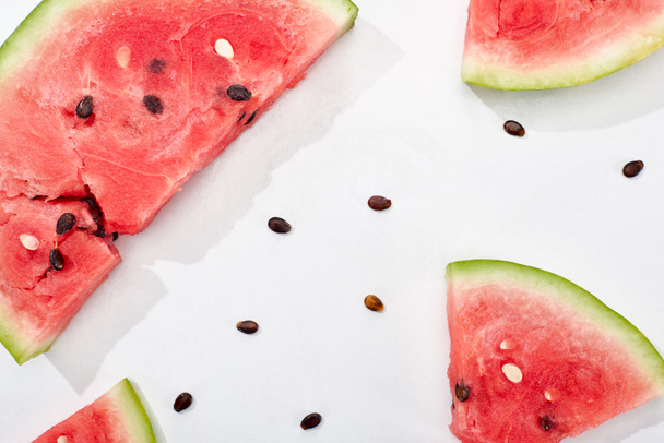 top view of juicy watermelon slices with seeds on white background - Foto, afbeelding