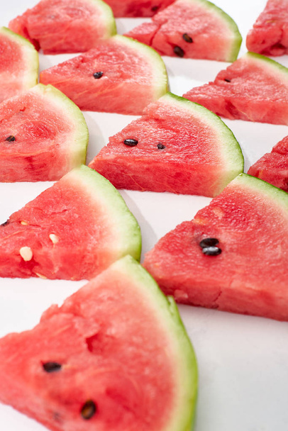 heerlijke sappige watermeloen plakjes in rijen op witte achtergrond - Foto, afbeelding