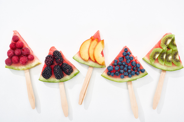 top view of delicious watermelon on sticks with seasonal berries and fruits - Fotó, kép