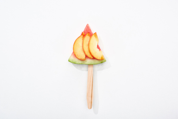 top view of delicious watermelon on stick with nectarine on white background - Fotó, kép