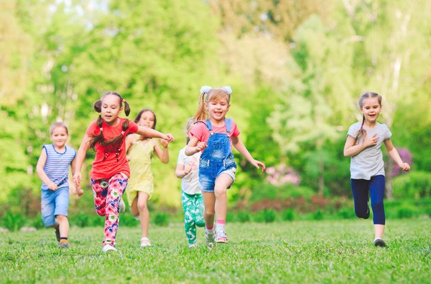 Many different kids, boys and girls running in the park on sunny summer day in casual clothes - Fotoğraf, Görsel