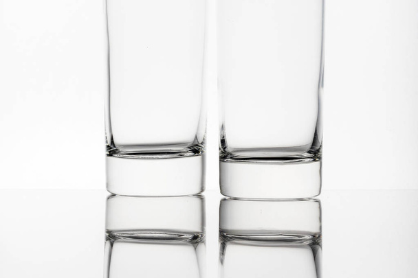 two clear empty glasses isolated on white background in studio  - Zdjęcie, obraz