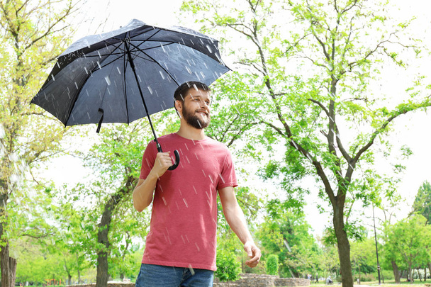 Bonito homem com guarda-chuva ao ar livre
 - Foto, Imagem