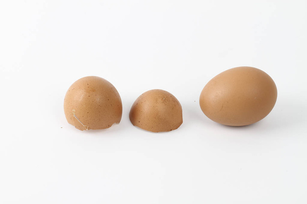 beige hen eggs and broken egg shells  - Фото, зображення