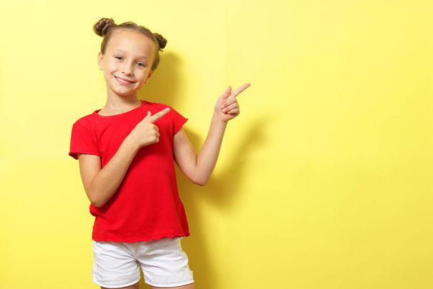 Little cheerful smiling girl in fashionable clothes on a colored background. Children's clothing, children's fashion - Fotografie, Obrázek