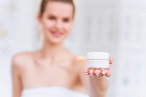 Woman holds a organic natural cream in her hand to moisturize her skin and wrinkle from impurities. Beauty, body care, skincare concept. - Φωτογραφία, εικόνα
