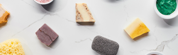 panorámaképet különböző szappan, habkő, fürdő szivacsból és agyagmaszk márványfelületen - Fotó, kép
