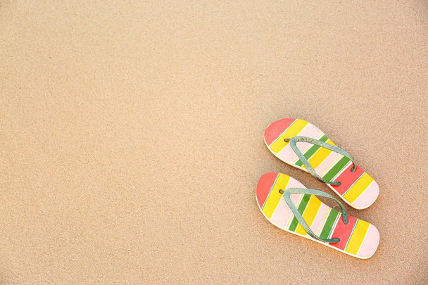 Stylish flip flops on sand, top view with space for text. Beach accessories - Photo, image
