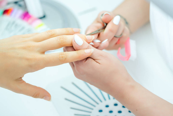 Mulher com as unhas cortadas durante a manicure
 - Foto, Imagem